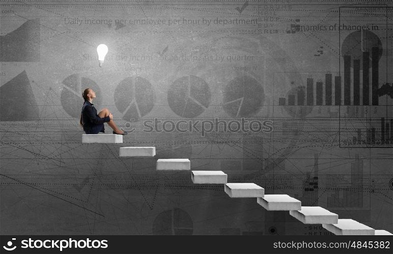 She is in dispair and isolation. Bored young businesswoman sitting alone on ladder steps
