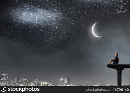 She is in dispair and isolation. Bored young businesswoman sitting alone on top