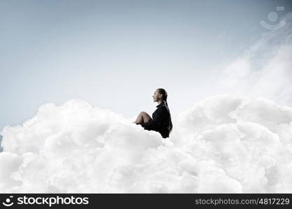 She is in dispair and isolation. Thoughtful young businesswoman sitting alone on cloud high in sky