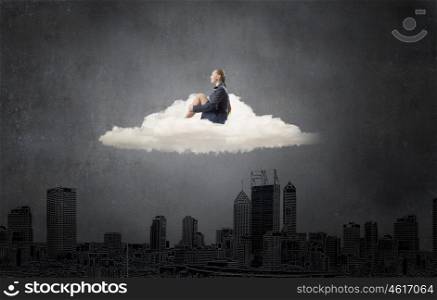 She is in dispair and isolation. Thoughtful young businesswoman sitting alone on cloud above city