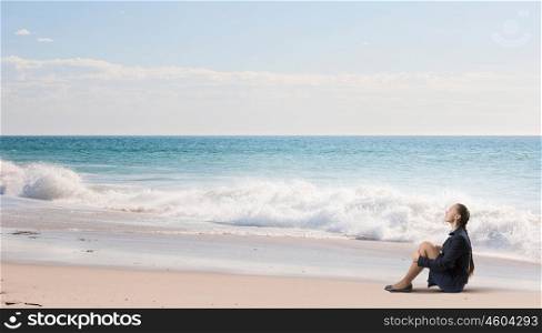 She is in dispair and isolation. Thoughtful young businesswoman sitting alone on ocean coast