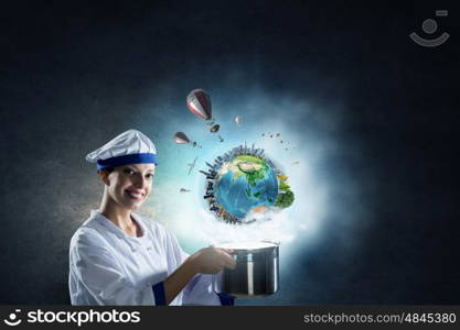 She is magician as cook. Pretty woman cook in hat and apron with pot in hands. Elements of this image are furnished by NASA