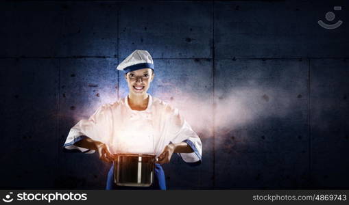 She is magician as cook. Pretty woman cook in hat and apron with pot in hands