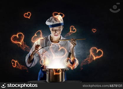 She is magician as cook. Pretty woman cook in hat and apron opening pot