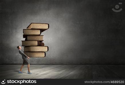 She is mastering the science. Young businesswoman carrying pile of old books