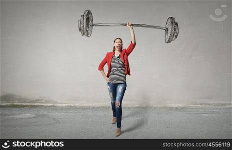 She is powerful and determined. Young woman in red jacket lifting barbell above head