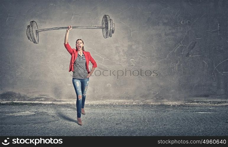 She is powerful and determined. Young woman in red jacket lifting barbell in one hand