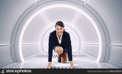 She is ready to challege it mixed media. Determined businesswoman in futuristic room ready to run