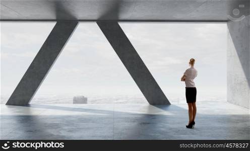 She is ready to face new day. Businesswoman in modern interior looking in office window