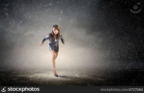 She is ready to run this race. Young determined businesswoman on road standing in start position