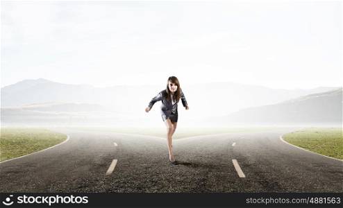She is ready to run this race. Young determined businesswoman on road standing in start position