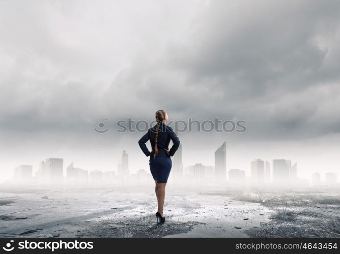 She is self assured. Back view of confident businesswoman with arms on waist