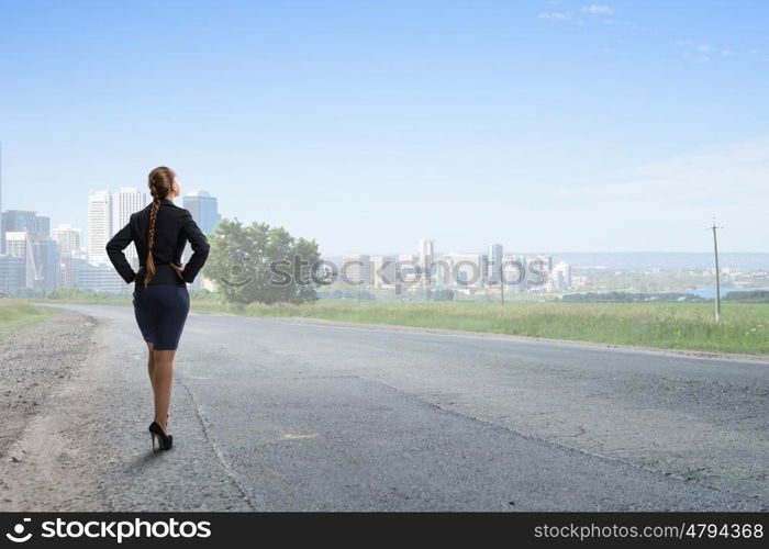 She is self assured. Back view of confident businesswoman with arms on waist