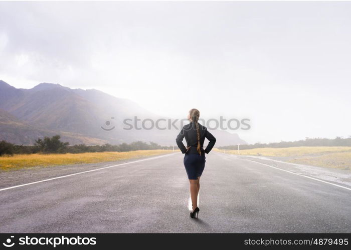 She is self assured. Back view of confident businesswoman with arms on waist