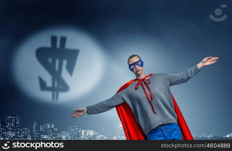 She is super woman. Young confident woman in red cape and mask