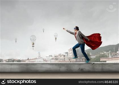 She is super woman. Young determined woman in red cape and mask