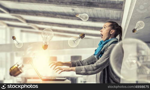 She is surfing the Internet. Young hipster girl sitting at table and working on laptop