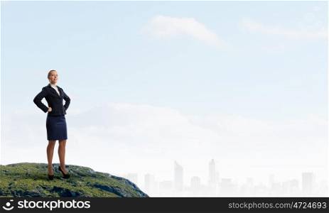 She is top manager. Confident businesswoman with arms on waist standing on top