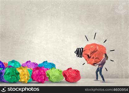 She is working hard on her new idea. Woman carrying with effort big crumpled ball of paper as creativity sign