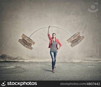 She masters knowledge. Young woman student in red jacket lifting barbell above head