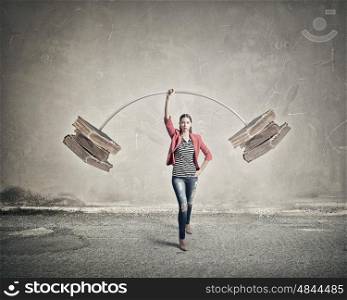 She masters knowledge. Young woman student in red jacket lifting barbell above head