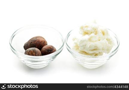 Shea butter and nuts in glass bowls isolated on white