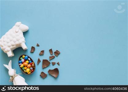 sheep bunny statuettes near chocolate egg