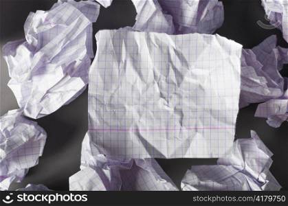 sheet of paper and crumpled wads on table.