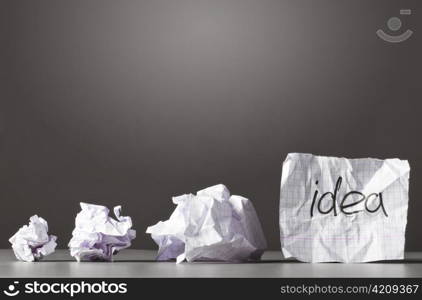 sheet of paper and crumpled wads on table.