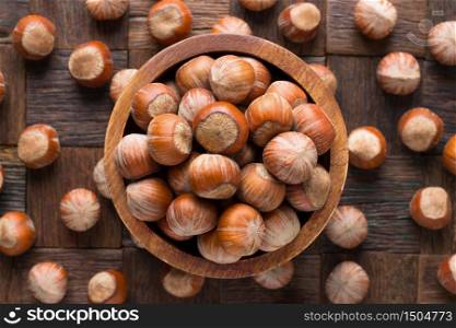 shelled hazelnut in bowl on wooden table background.