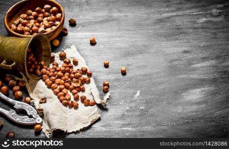 Shelled hazelnuts with Nutcracker and mortar of the old fabric. On the black wooden table.. Shelled hazelnuts with Nutcracker and mortar of the old fabric.