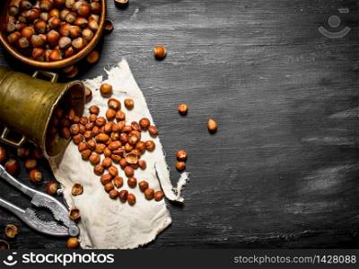 Shelled hazelnuts with Nutcracker and mortar of the old fabric. On the black wooden table.. Shelled hazelnuts with Nutcracker and mortar of the old fabric.