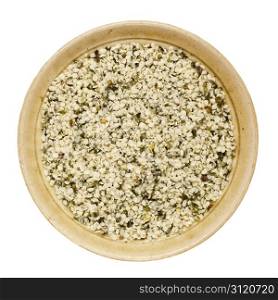 shelled hemp seeds in a round ceramic bowl isolated on white