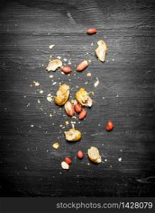 Shelled peanuts with the shell. On the black wooden table.. Shelled peanuts with the shell.