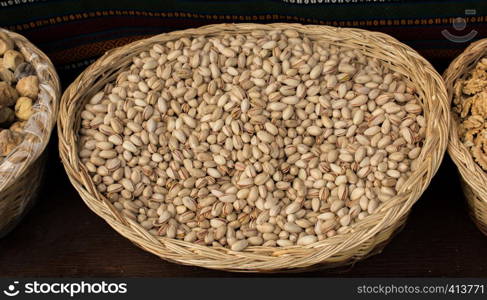 Shelled pistachio nuts in a straw basket on display