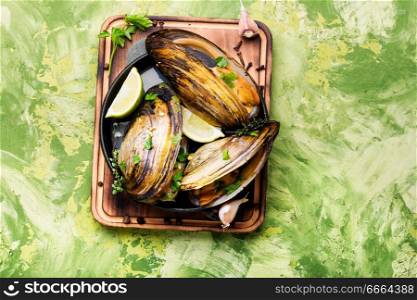Shellfish mussels in pan with lemon and herbs.Seafood mussels with lemon. Seafood. Delicious seafood mussels