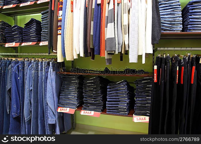 Shelves and racks with clothes in shop