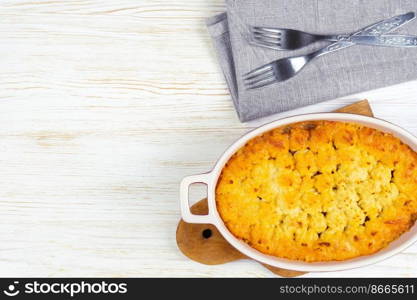 Shepherd&rsquo;s pie or Cottage pie. Minced meat, mashed potatoes and vegetables casserole on white wooden background. Traditonal British, United Kingdom, Ireland cuisine. Top view, flat lay with copy space. Shepherd&rsquo;s Pie or Cottage Pie, traditional British dish on white wooden background