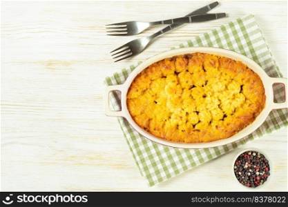 Shepherd’s pie or Cottage pie. Minced meat, mashed potatoes and vegetables casserole on white wooden background. Traditonal British, United Kingdom, Ireland cuisine. Top view, flat lay with copy space. Shepherd’s Pie or Cottage Pie, traditional British dish on white wooden backgfound
