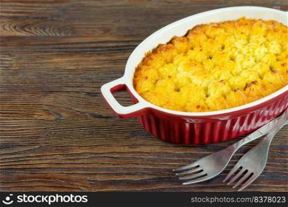 Shepherd’s pie or Cottage pie. Minced meat, mashed potatoes and vegetables casserole on brown wooden background with copy space for text. Traditonal British, United Kingdom, Ireland cuisine. Shepherd’s Pie or Cottage Pie, traditional British dish on brown wooden backgfound