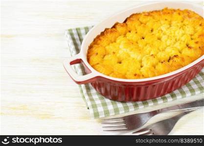 Shepherd’s pie or Cottage pie. Minced meat, mashed potatoes and vegetables casserole on white wooden background with copy space for text. Traditonal British, United Kingdom, Ireland cuisine. Shepherd’s Pie or Cottage Pie, traditional British dish on white wooden backgfound