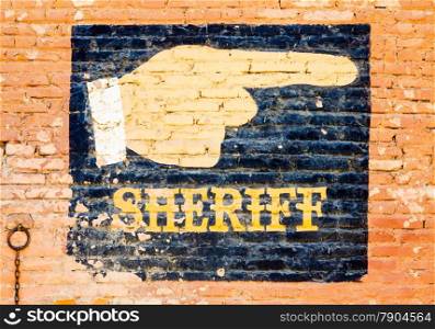 Sheriff graffiti on an old brick wall. Concept for security
