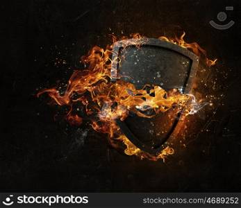 Shield burning in fire. Stone broken shield in fire flames on dark background