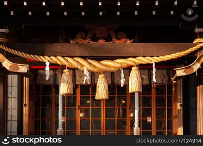 Shimenawa sacred rope under warm evening sunset light at Hiei shrine Yamadera Risshaku ji temple. Yamagata - Japan