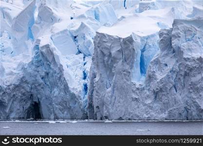 Shimmering dark blue caves and crevices and cracks in a huge glacier tongue in Antarctica