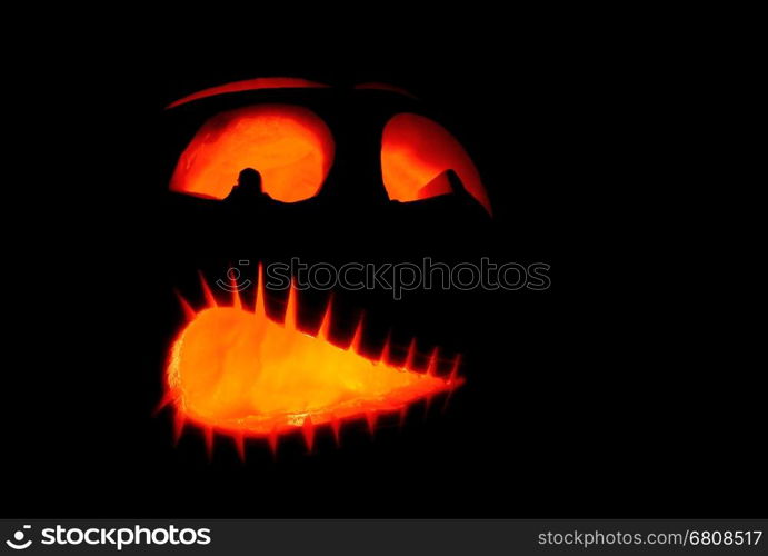 Shining scary halloween pumpkin face at night.