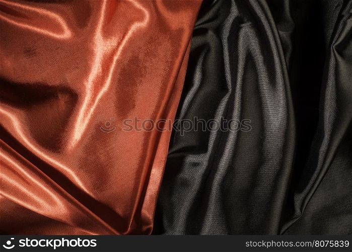 Shiny black and red satin pleated fabric background. Close up