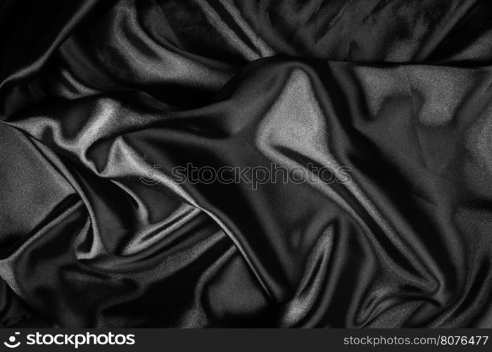 Shiny black satin pleated fabric background. Close up