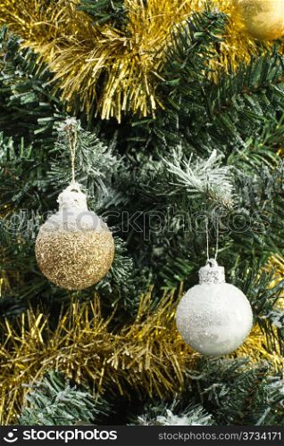 shiny christmas balls on christmas tree covered with snow