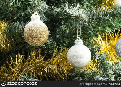 shiny christmas balls on christmas tree covered with snow